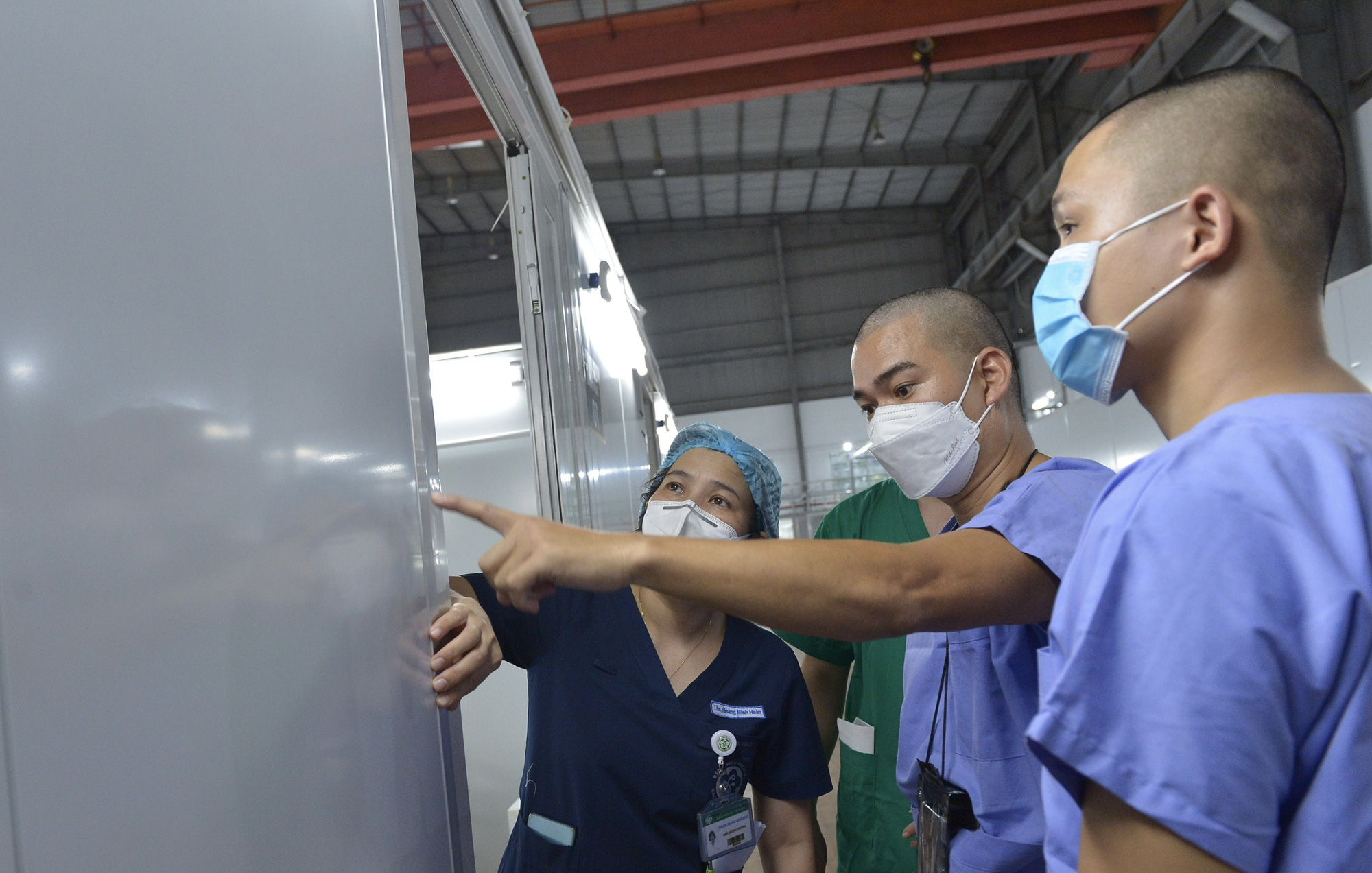 Doctors and nurses examine a patient room at an intensive care center for COVID-19 treatment in Ho Chi Minh City. Photo: Tu Trung / Tuoi Tre