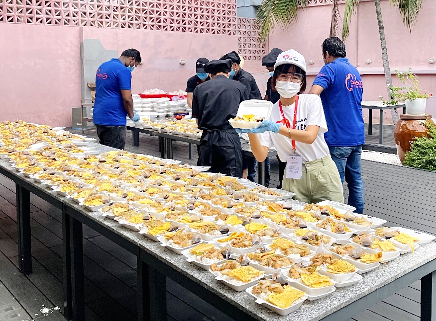 The members of the team ‘Viet Nam oi co len!’ prepare meals before delivering them to the needy and frontline medical workers. There are about 80 members in the team. Photo: VNOCL