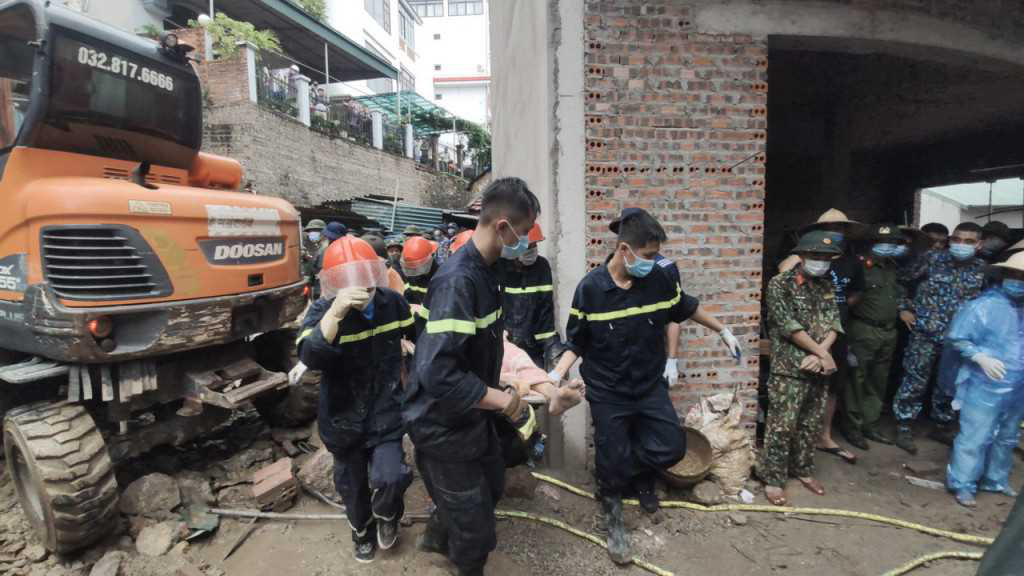 Rescuers take a victim out of debris in a landslide in Ha Long City, Quang Ninh Province, Vietnam, August 12, 2021. Photo: Hang Ngan / Tuoi Tre
