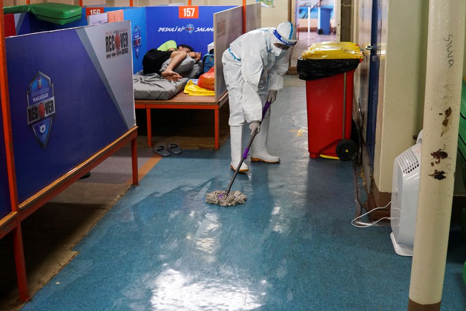 A worker wearing personal protective equipment (PPE) disinfects the floor on the deck of a passenger ship, owned by the state-owned shipping company PT PELNI, KM Umsini, which has been modified to an isolation centre for the coronavirus disease (COVID-19) patients in Makassar, South Sulawesi province, Indonesia, August 8, 2021. Photo: Reuters