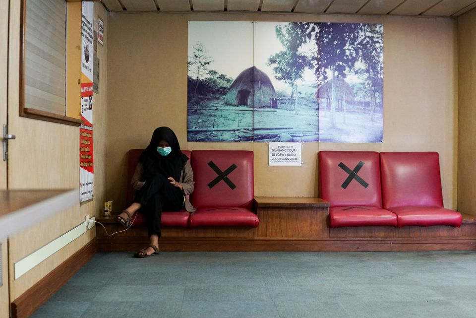 A patient wearing a protective mask sits on a bench at the deck of a passenger ship, owned by the state-owned shipping company PT PELNI, KM Umsini, modified to an isolation centre for the coronavirus disease (COVID-19) patients in Makassar, South Sulawesi province, Indonesia, August 8, 2021. Photo: Reuters