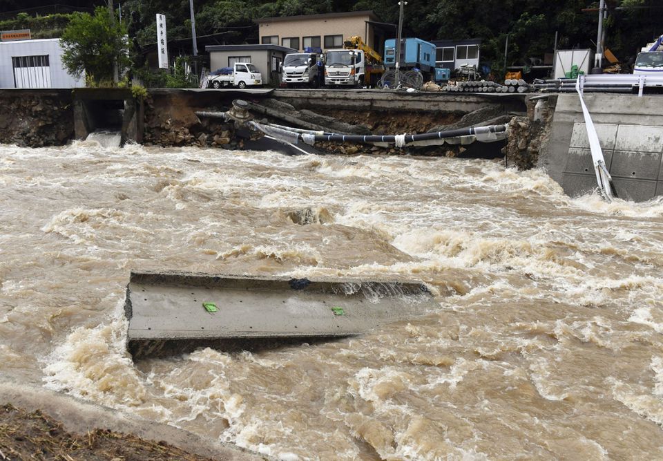 A road is damaged by the swollen Suzuhari river caused by a heavy rain in Hiroshima, western Japan August 13, 2021, in this photo taken by Kyodo. Mandatory credit Kyodo/via Reuters