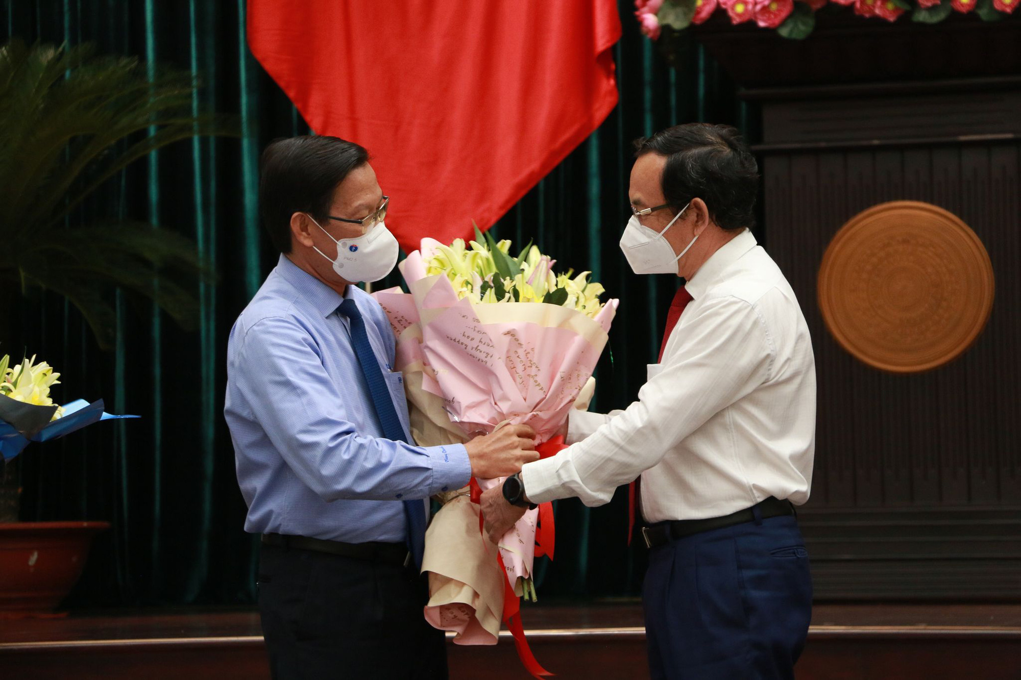 Chairman of the Ho Chi Minh City People’s Committee Phan Van Mai (L) receives flowers from Secretary of the city’s Party Committee Nguyen Van Nen, August 24, 2021. Photo: T.H. / Tuoi Tre