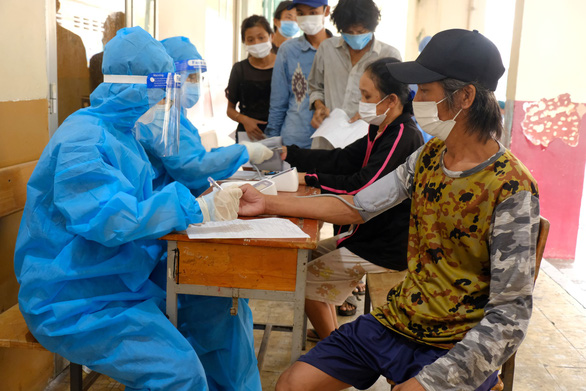 Medical officers perform health screening before inoculating homeless people against COVID-19 at a shelter in District 4 of Ho Chi Minh City. Photo: Vu Thuy / Tuoi Tre