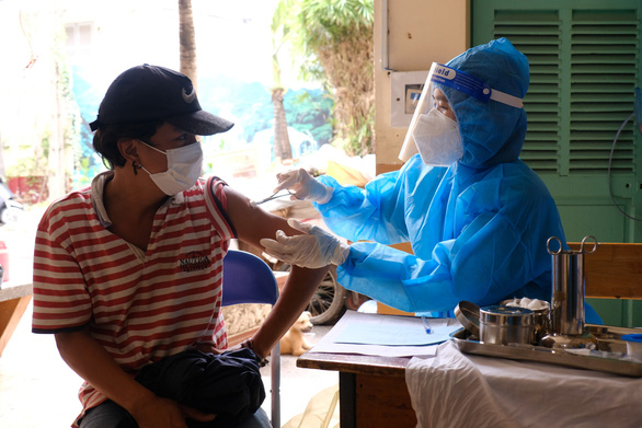 A medical officer inoculates a homeless person against COVID-19 at a shelter in District 4 of Ho Chi Minh City. Photo: Vu Thuy / Tuoi Tre