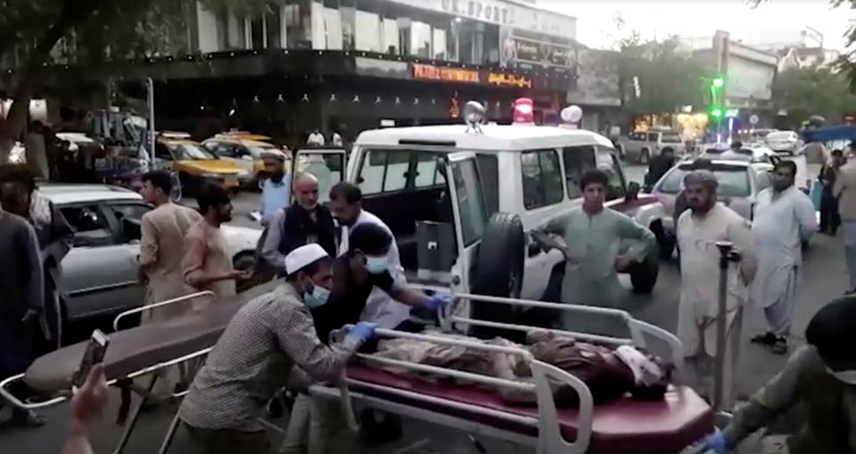 A screen grab shows people carrying an injured person to a hospital after an attack at Kabul airport, in Kabul, Afghanistan August 26, 2021. Photo: Reuters TV/1TV/Handout via Reuters