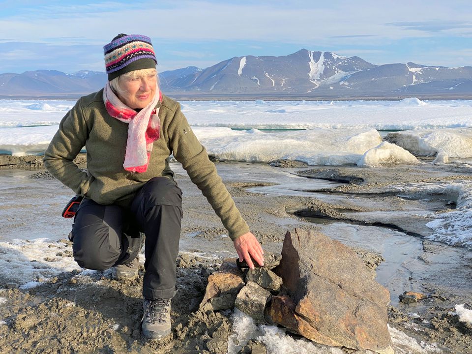An undated handout image of Swiss entrepreneur Christiane Leister, creator of the Leister Foundation that financed an expedition which discovered a tiny island off the coast of Greenland which they say is the world's northernmost point of land, in front of a cairn in which expedition members left a message with details of their visit. Julian Charriere/via Reuters