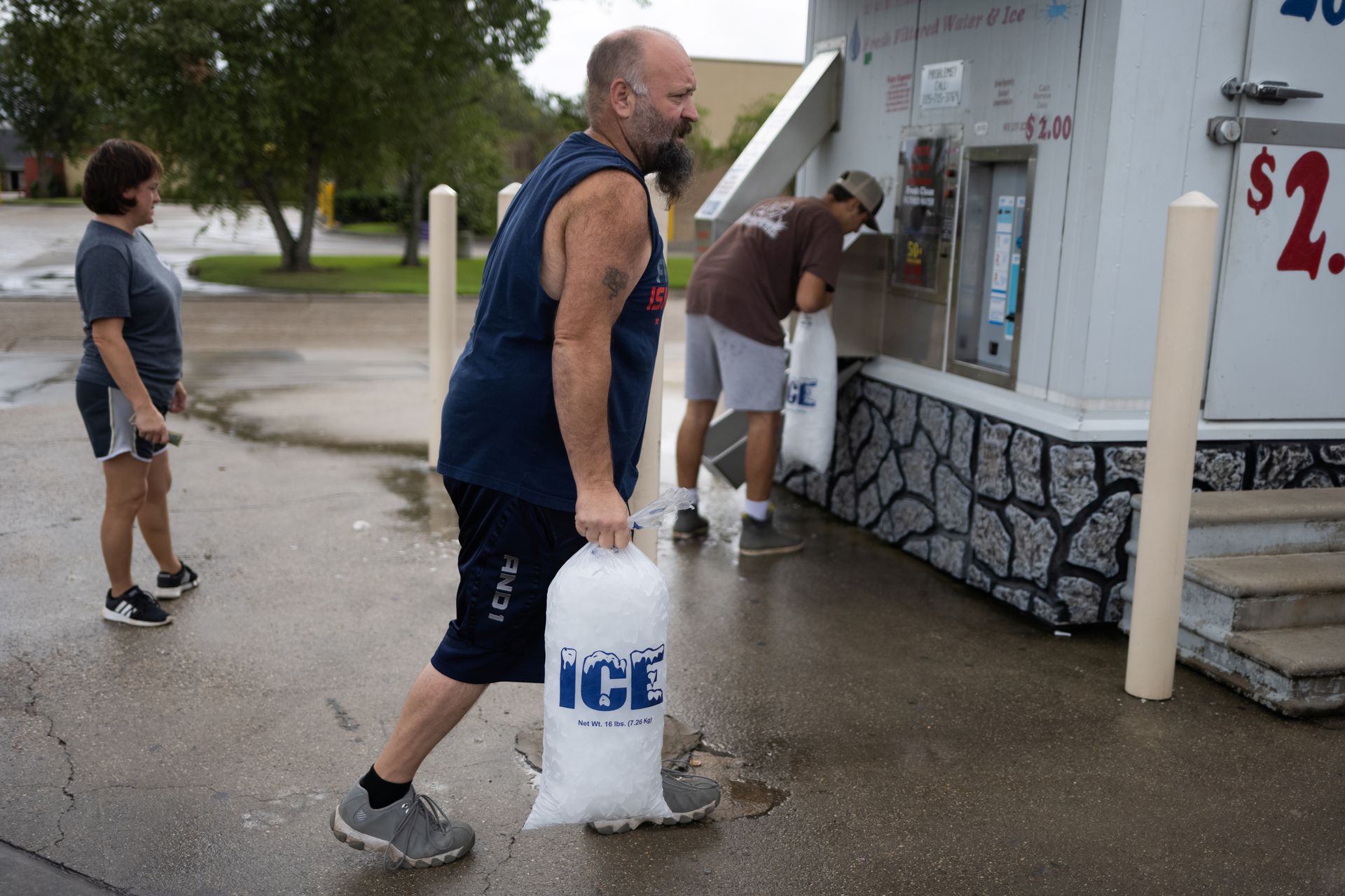 Local resident Mark Mayon carries a bag of ice past others while preparing for the arrival of Hurricane Ida in Morgan City, Louisiana, U.S., August 29, 2021. Photo: Reuters