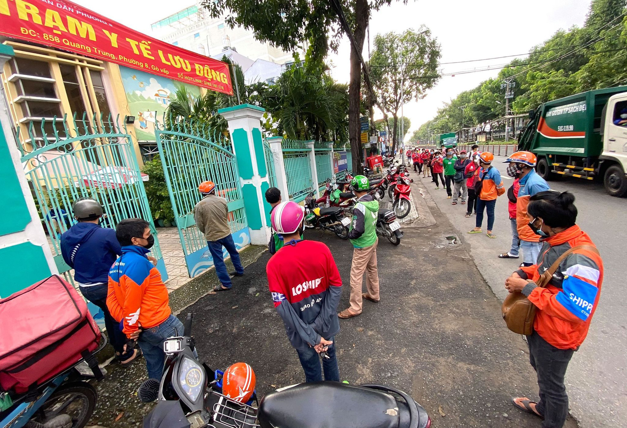 Delivery workers wait in front of a medical station in Go Vap District, Ho Chi Minh City, August 31, 2021. Photo: Quang Dinh / Tuoi Tre