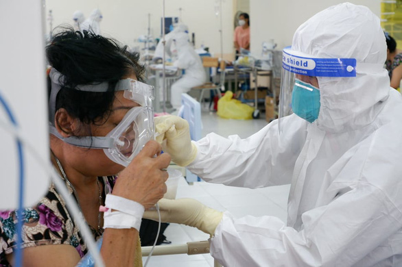 A volunteer supports a coronavirus patient in Ho Chi Minh City. Photo: Kim Ut / Tuoi Tre