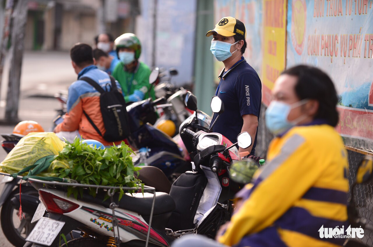Delivery workers wait in front of a medical station in Go Vap District, Ho Chi Minh City, August 31, 2021. Photo: Quang Dinh / Tuoi Tre