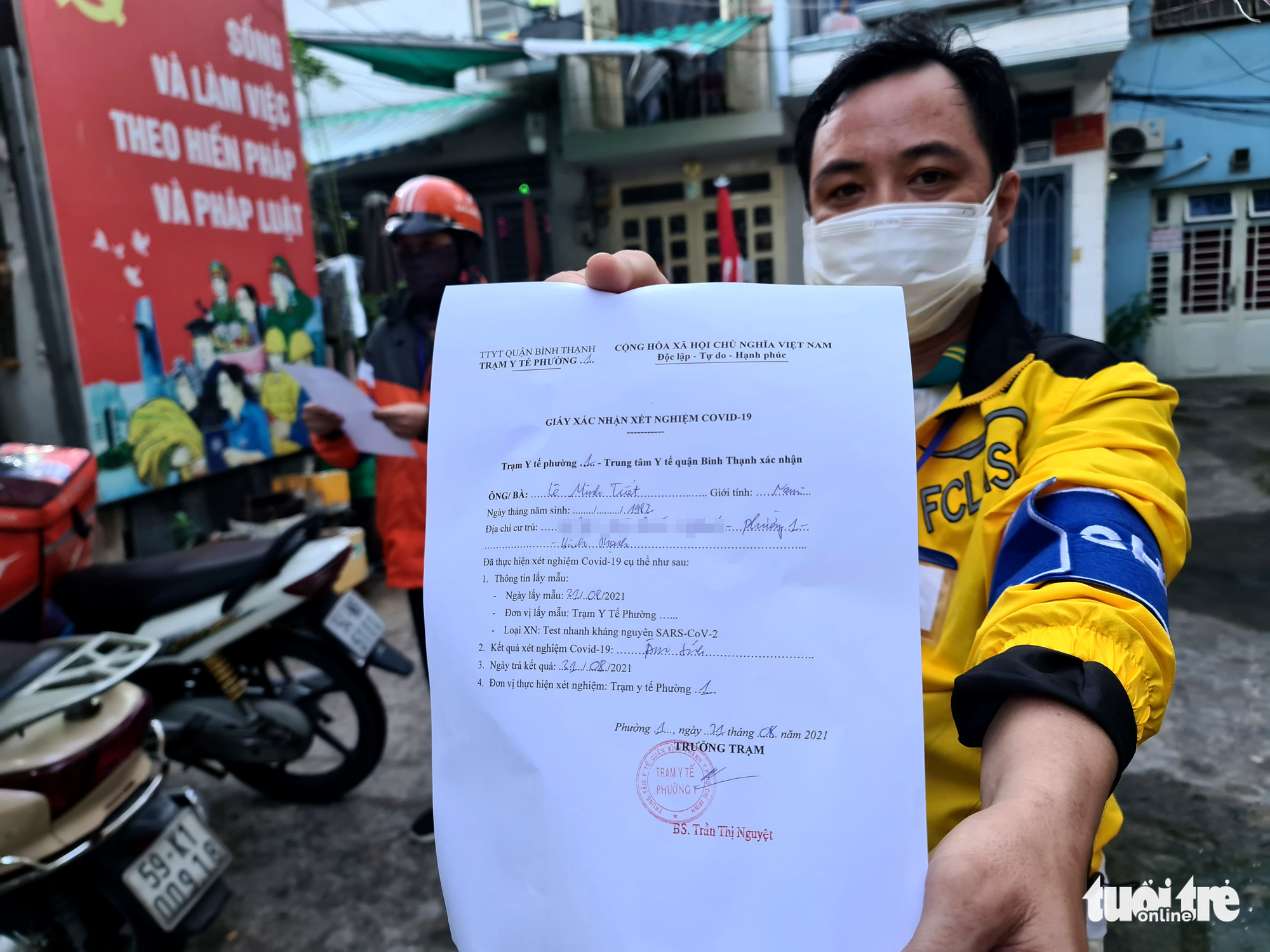 A delivery worker shows his negative test result in Binh Thanh District, Ho Chi Minh City, August 31, 2021. Photo: Ngoc Hien / Tuoi Tre