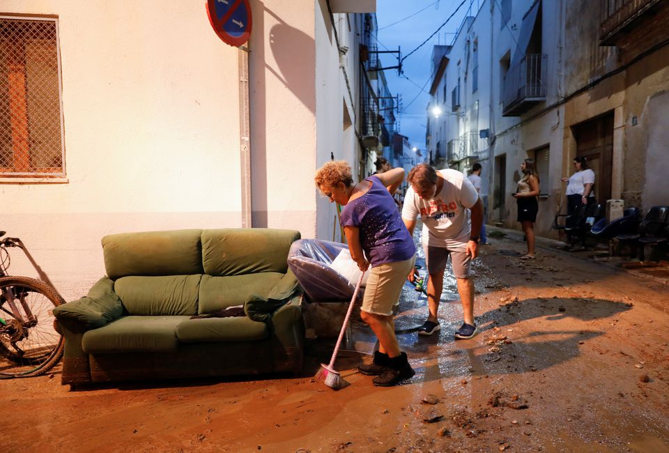 People clean the mud of a street after floods caused by heavy rains in Alcanar, Spain, September 1, 2021. Photo: Reuters