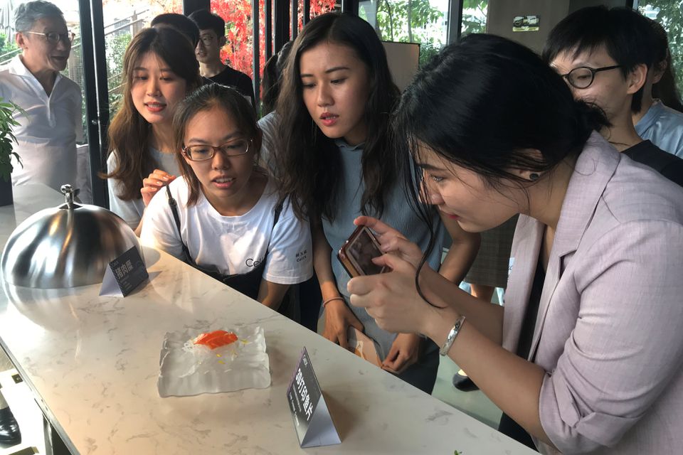Guests look at a 3D printed salmon slice displayed during an event by CellX, a cultivated meat startup, to introduce product prototypes in Shanghai, China September 3, 2021. Photo: Reuters