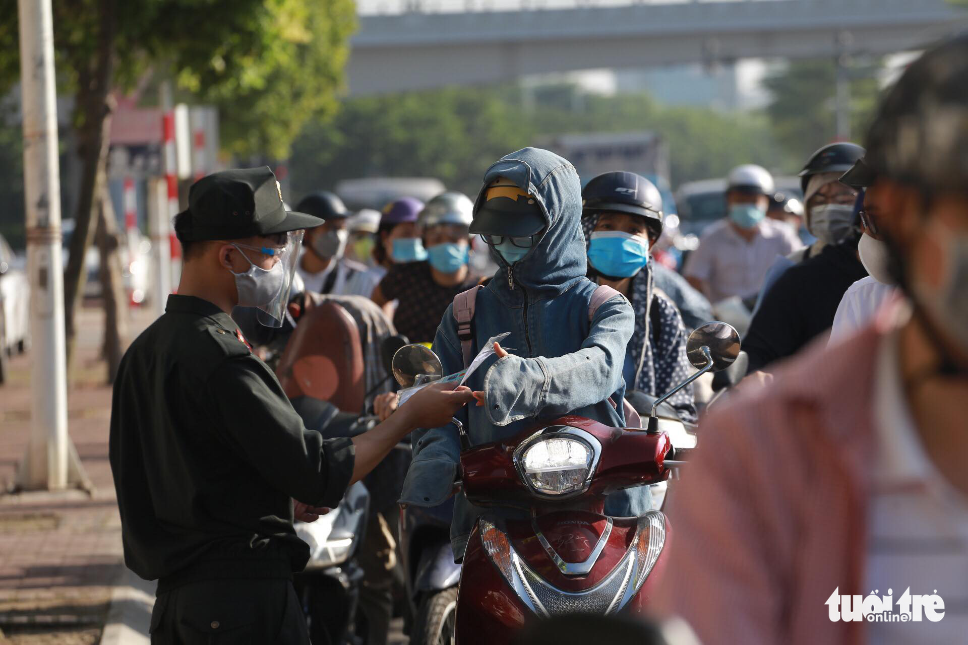 An officer checks documents of commuters in Hanoi, September 6, 2021. Photo: Chi Tue / Tuoi Tre