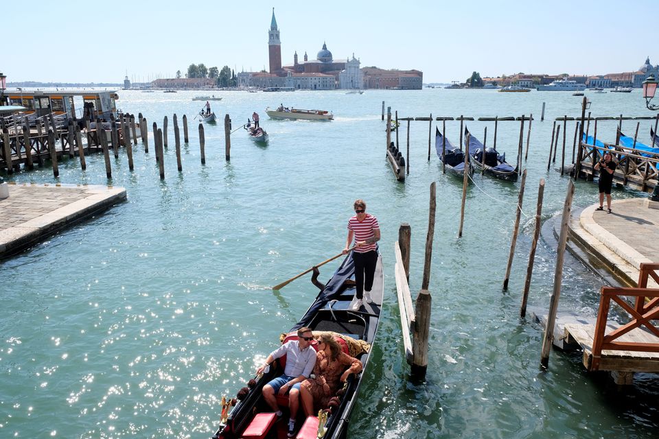 People ride on a gondola as the municipality prepares to charge tourists up to 10 Euro for entry into the lagoon city, in order to cut down the number of visitors, in Venice, Italy, September 5, 2021. Photo: Reuters