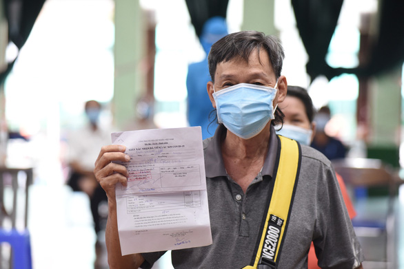 A senior citizen shows his vaccination certificate after getting his second jab in District 11 of Ho Chi Minh City, Vietnam. Photo: Duyen Phan / Tuoi Tre