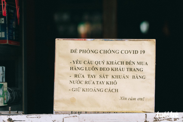 COVID-19 safety rules are written on a sign in front of a shop in Hanoi, September 16, 2021. Photo: Pham Tuan / Tuoi Tre