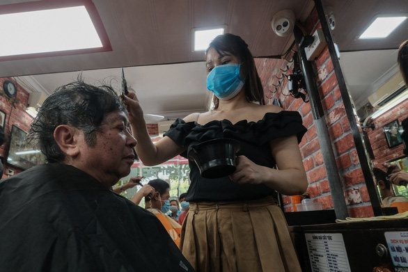 A resident gets a haircut at a barbershop in Dong Da District, Hanoi, September 21, 2021. Photo: Mai Thuong / Tuoi Tre