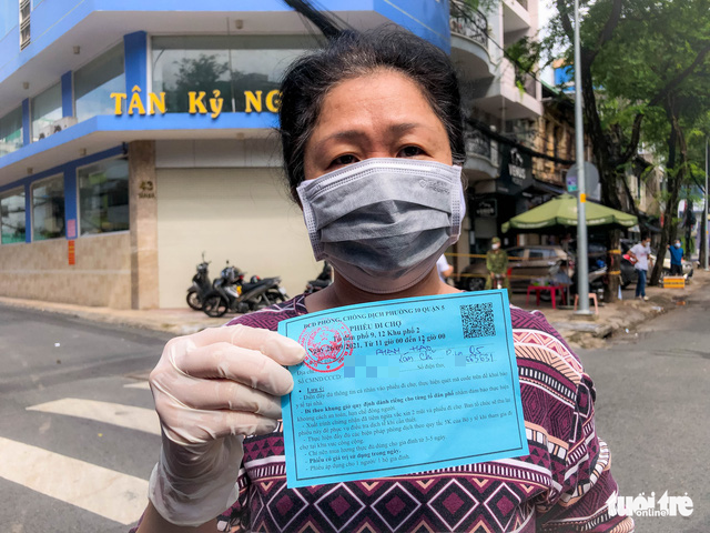 A resident shows a ticket to enter the makeshift market in District 5, Ho Chi Minh City, September 26, 2021. Photo: Chau Tuan / Tuoi Tre