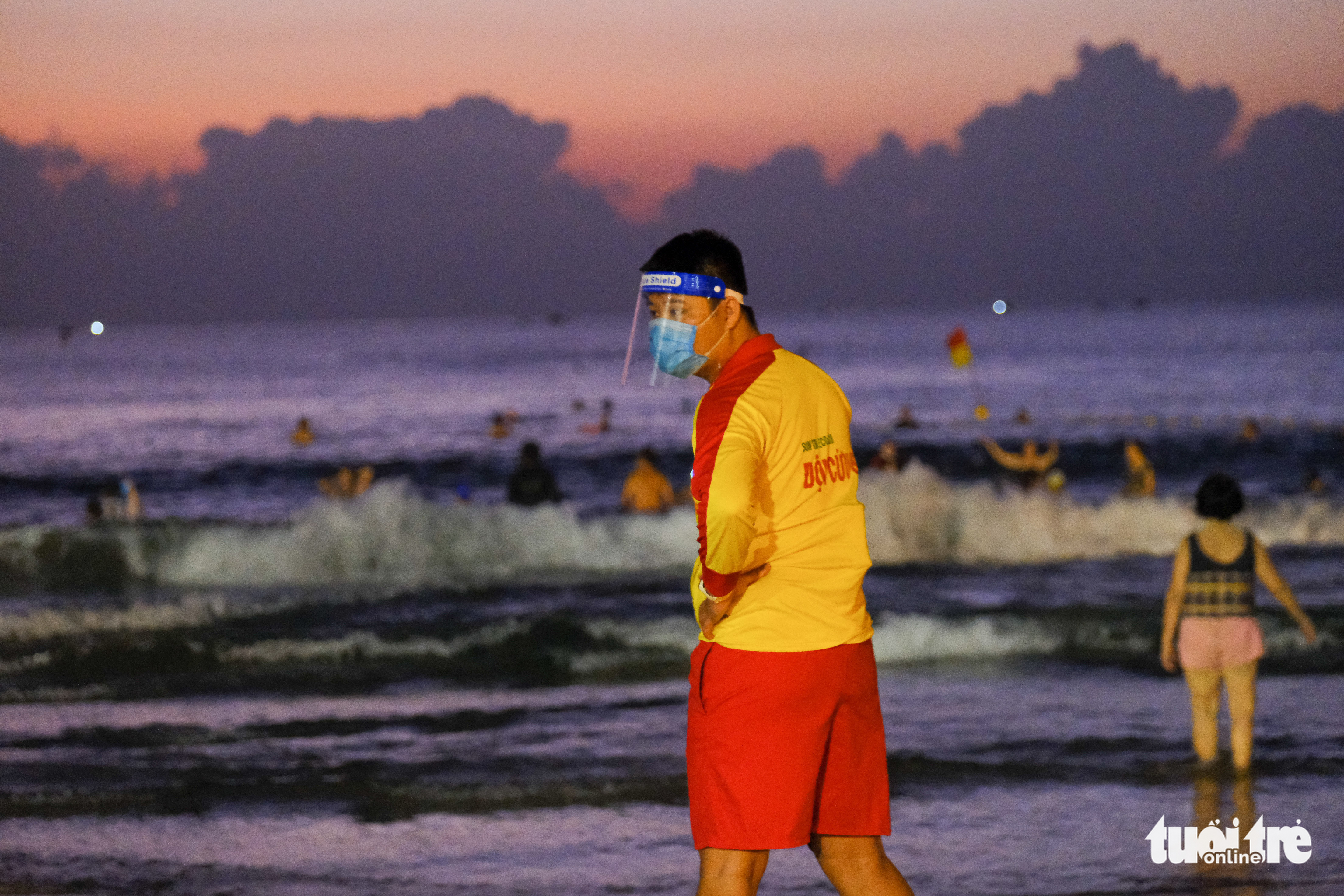 A lifeguard wears a face masks and face shield while on duty at a beach in Da Nang, September 30, 2021. Photo: Tan Luc / Tuoi Tre