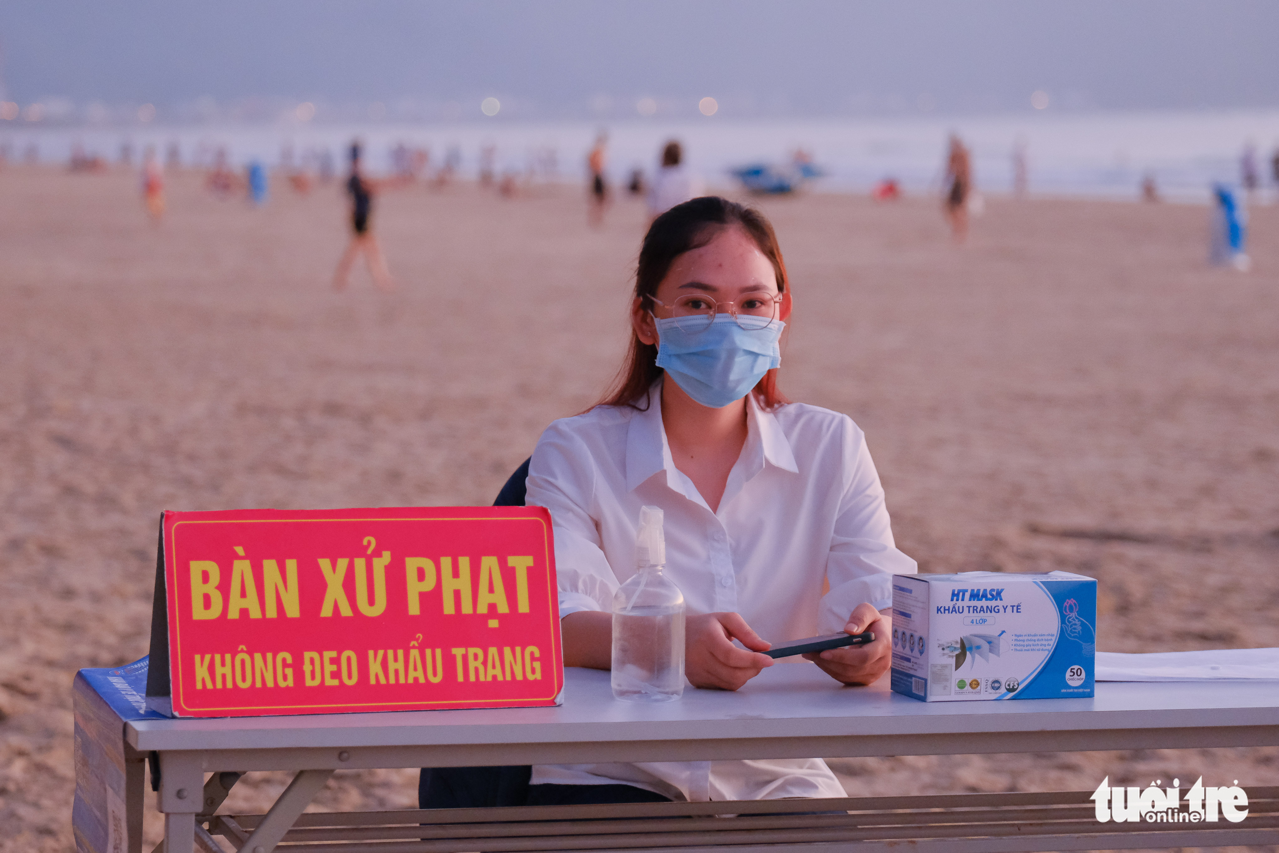A woman is put in charge of imposing fines on violators of pandemic prevention and control regulations at a beach in Da Nang, September 30, 2021. Photo: Tan Luc / Tuoi Tre