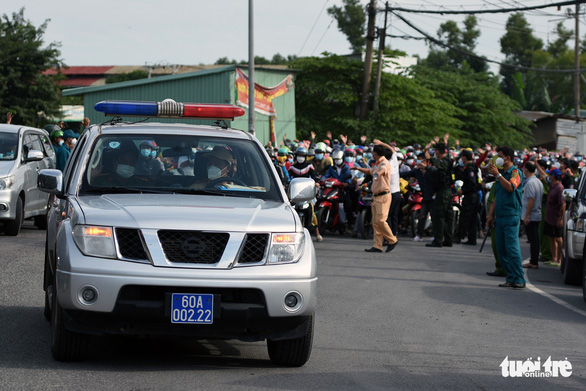 Functional forces prepare a police car to lead domestic migrant workers during their motorbike trip back to hometown in Vinh Cuu District, Dong Nai Province, Vietnam, October 2, 2021. Photo: A Loc / Tuoi Tre