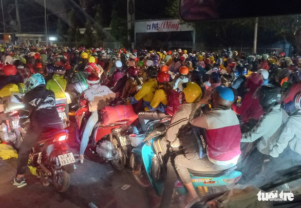 Numerous people are seen at a gateway to Long Xuyen City, An Giang Province on the evening of October 2, 2021. Photo: Minh Tri / Tuoi Tre