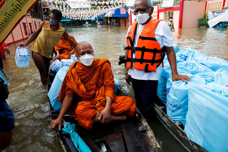 Buddhist monks deliver aid on a boat at a flooded area, at a temple in Ayutthaya, Thailand, October 6, 2021. Photo: Reuters