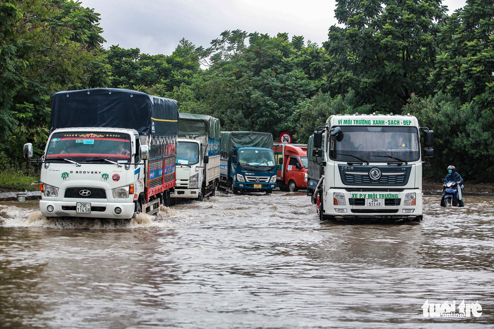 Trucks drive through flooding on the Thang Long Avenue in Hanoi, Vietnam, October 11, 2021. Photo: Nam Tran / Tuoi Tre