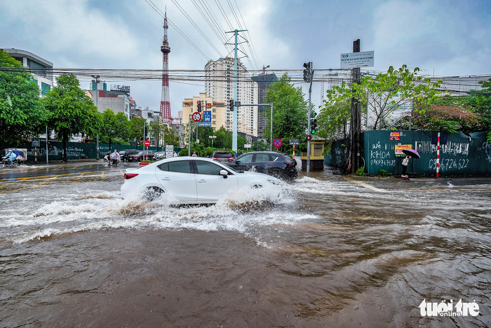 A car darts through flooding on the To Huu - Luong The Vinh intersection in Nam Tu Liem District, Hanoi, Vietnam, October 11, 2021. Photo: Nam Tran / Tuoi Tre