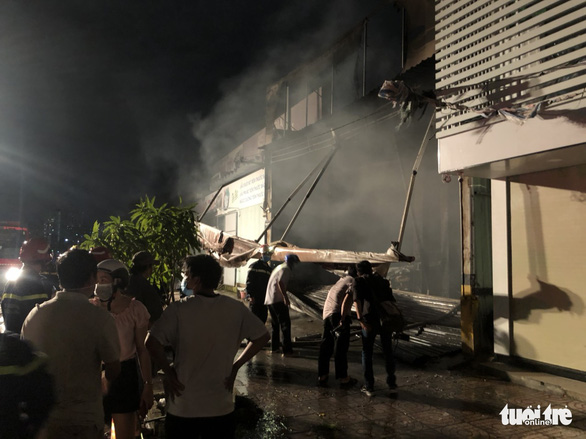 The door of a garage is knocked down to facilitate fire fighting at the venue in District 7, Ho Chi Minh City, October 13, 2021. Photo: Nguyen Hoang / Tuoi Tre
