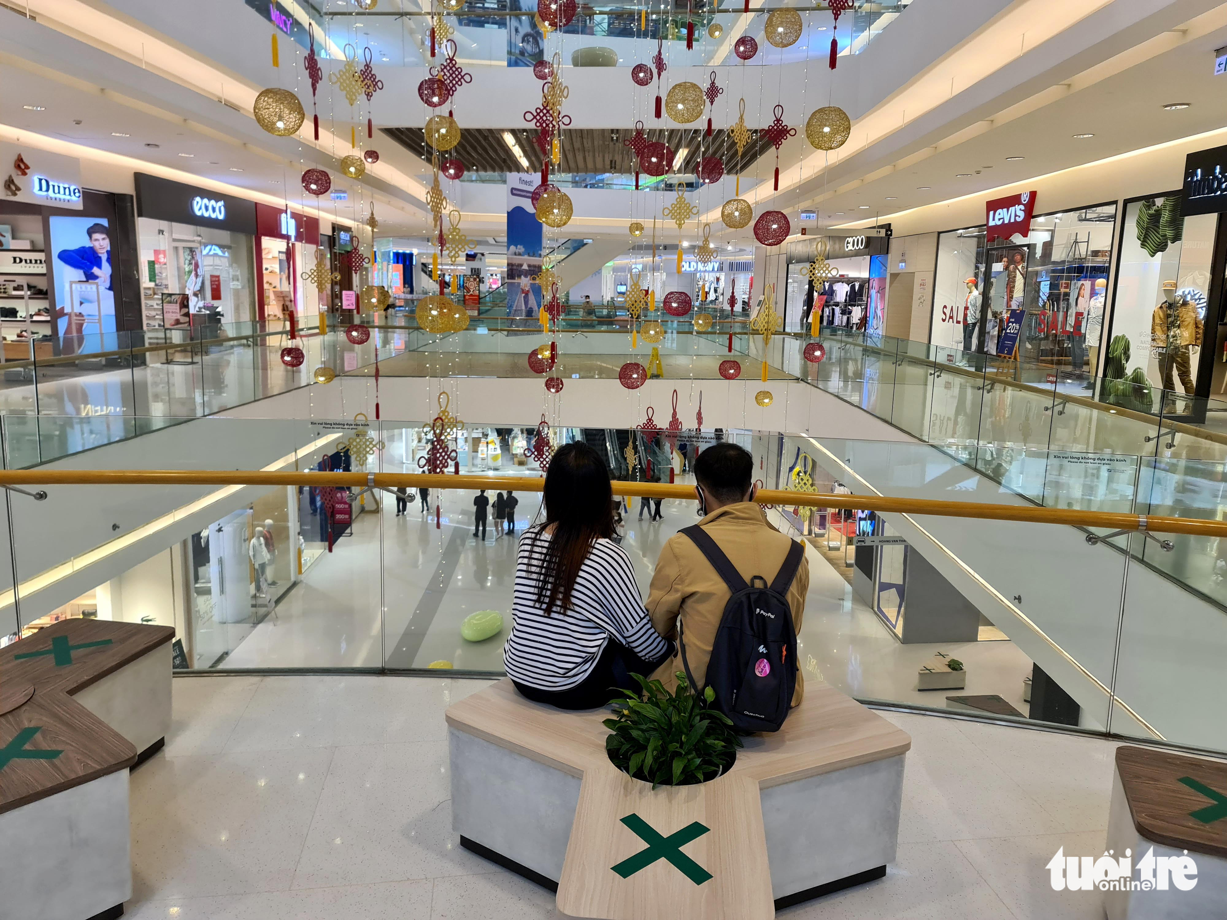 A couple sits on a chair at a shopping mall in District 7, Ho Chi Minh City, October 16, 2021. Photo: Ngoc Hien / Tuoi Tre
