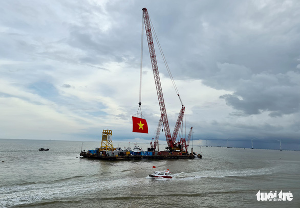 A Vietnamese national flag is raised during a ceremony at the Dong Hai 1 wind power project in Tra Vinh Province, Vietnam, October 17, 2021. Photo: Ngoc Hien / Tuoi Tre