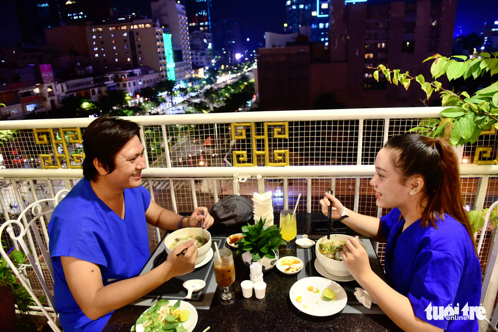 Cao Kim Thoa (right) and Nguyen Hoang Do, nurses at the COVID-19 Resuscitation Hospital in Thu Duc City chat together while enjoying pho at Rex Saigon Hotel in Ho Chi Minh City’s District 1 on October 14, 2021. Photo: Duyen Phan / Tuoi Tre