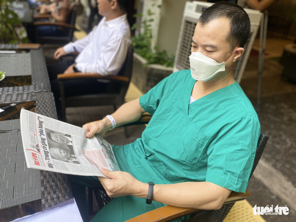 A medical worker reads Tuoi Tre Newspaper while waiting for his pho at Rex Saigon Hotel in Ho Chi Minh City’s District 1 on October 13, 2021. Photo: Duyen Phan / Tuoi Tre