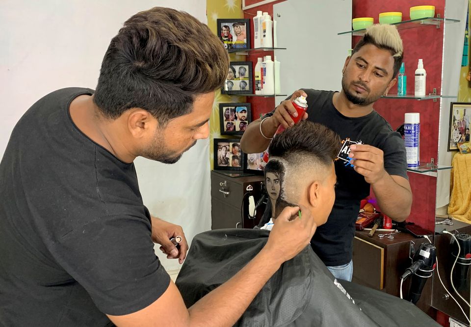 Barber brothers Rajwinder Singh Sidhu, 29, and Gurwinder Singh Sidhu, 31, make a haircut tattoo of Michael Jackson in a customer's hair inside their shop in Dabwali town, in the northern state of Punjab, India, October 11, 2021. Photo: Reuters