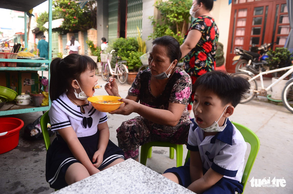 A woman feeds her grandchildren before they go to school in Thanh An Commune, Can Gio District, Ho Chi Minh City, October 20, 2021. Photo: Quang Dinh / Tuoi Tre