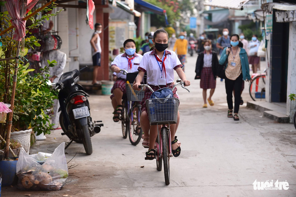Students cycle to school in Thanh An Commune, Can Gio District, Ho Chi Minh City, October 20, 2021. Photo: Quang Dinh / Tuoi Tre