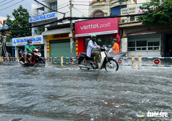 Motorcyclists drive through a flood in Go Vap District, Ho Chi Minh City, Vietnam, October 21, 2021. Photo: Chau Tuan / Tuoi Tre