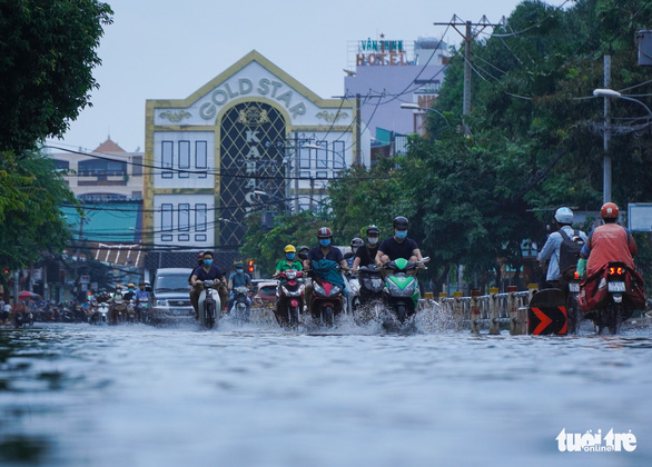 Motorcyclists drive through a flood in Go Vap District, Ho Chi Minh City, Vietnam, October 21, 2021. Photo: Chau Tuan / Tuoi Tre