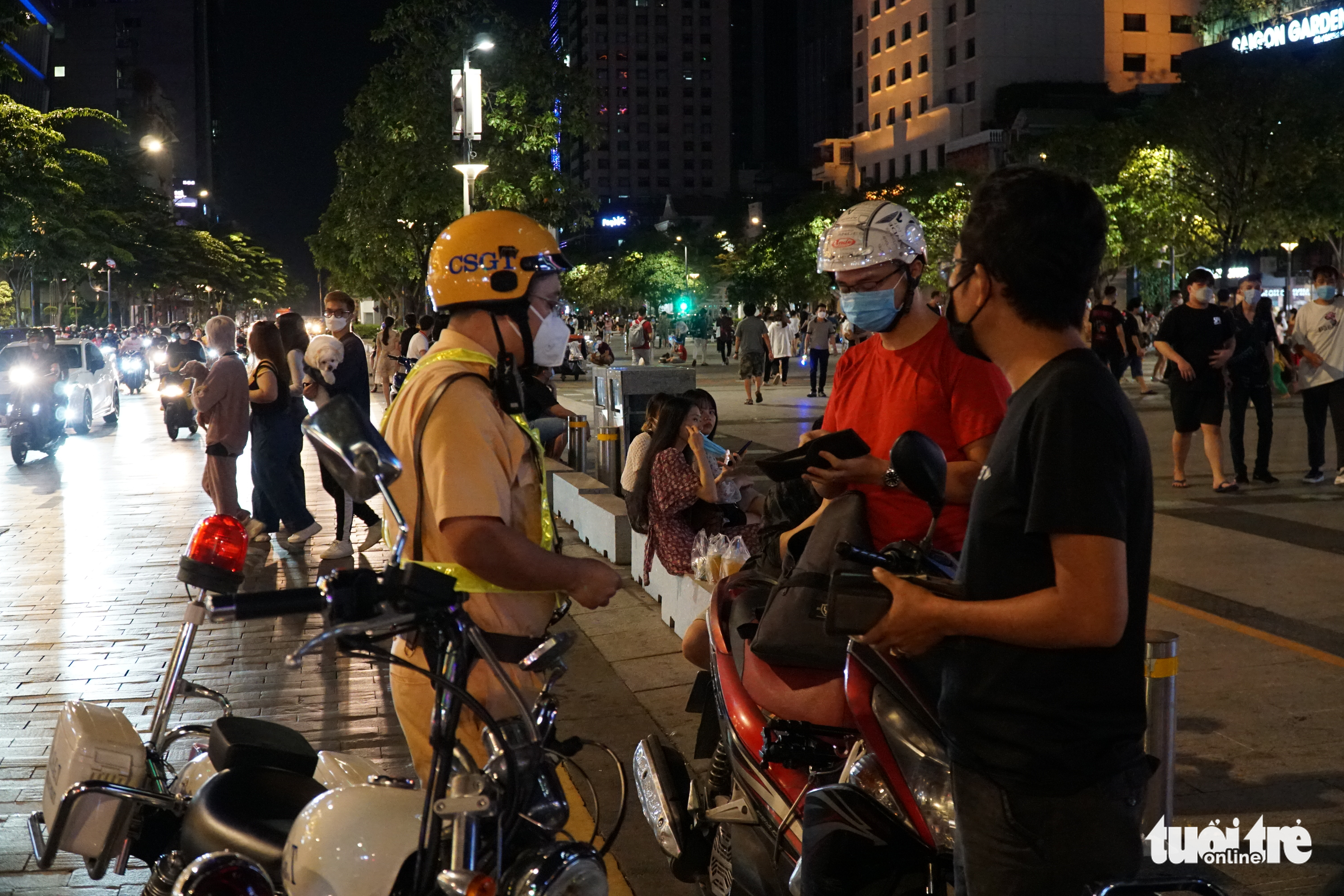 Residents are booked for parking their motorbikes on the roadway along Nguyen Hue Walking Street in Ho Chi Minh City, October 21, 2021. Photo: D.T. / Tuoi Tre