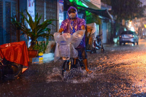 A citizen rides his electric bike through the flood in Phu Nhuan District, Ho Chi Minh City, Vietnam, October 21, 2021. Photo: Quang Dinh / Tuoi Tre