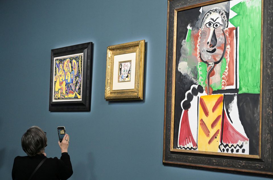 An attendee photographs a painting prior to the auction of 11 Picasso paintings and works at the Bellagio Hotel in Las Vegas, Nevada, U.S. October 23, 2021. Photo: Reuters