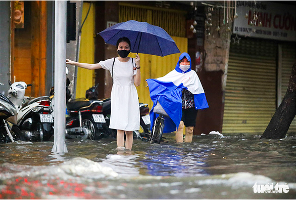Local citizens move through the flood in District 1, Ho Chi Minh City. October 24, 2021. Photo: Le Phan / Tuoi Tre