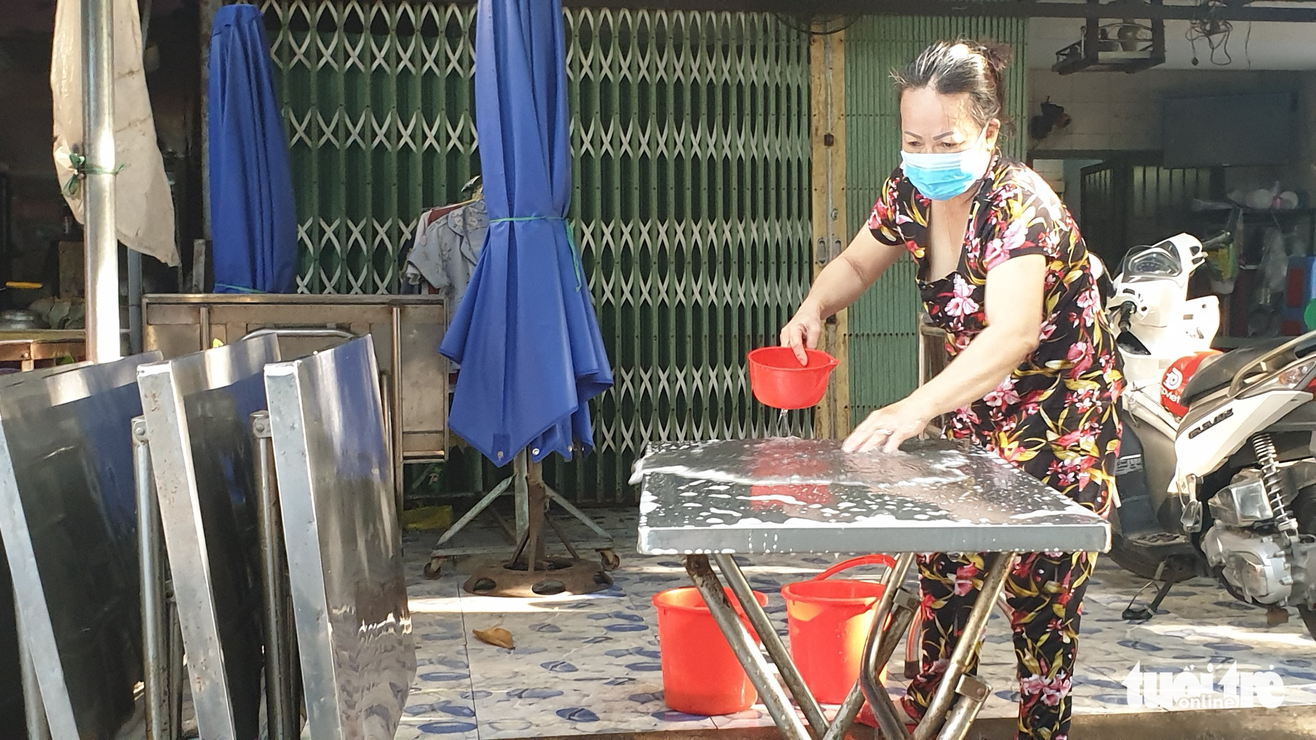 A woman washes tables to prepare for sit-down service in Ho Chi Minh City, October 28, 2021. Photo: Nguyen Tri / Tuoi Tre