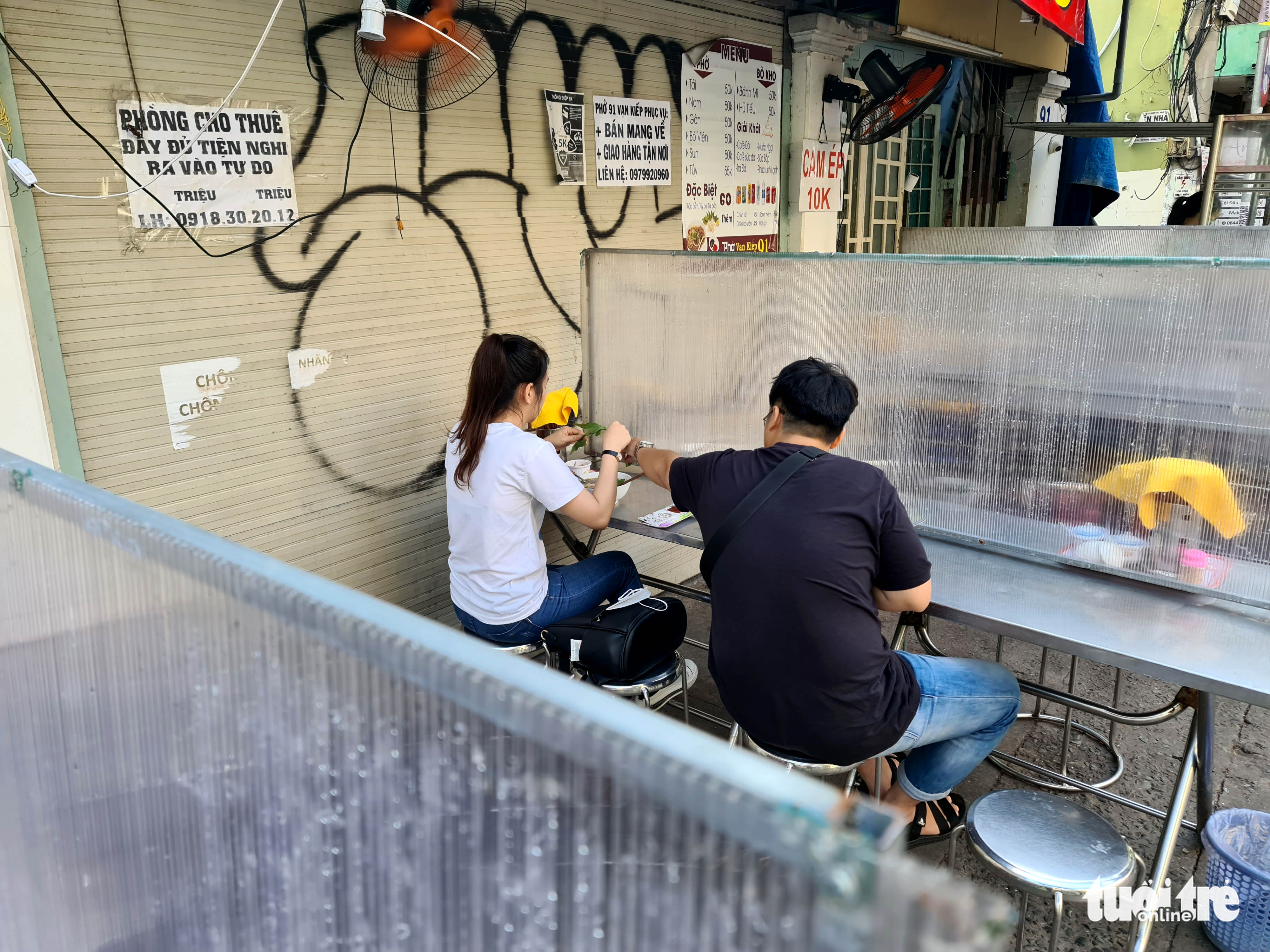 A pho shop installs partitions on tables as part of pandemic prevention and control measures. Photo: Ngoc Hien / Tuoi Tre