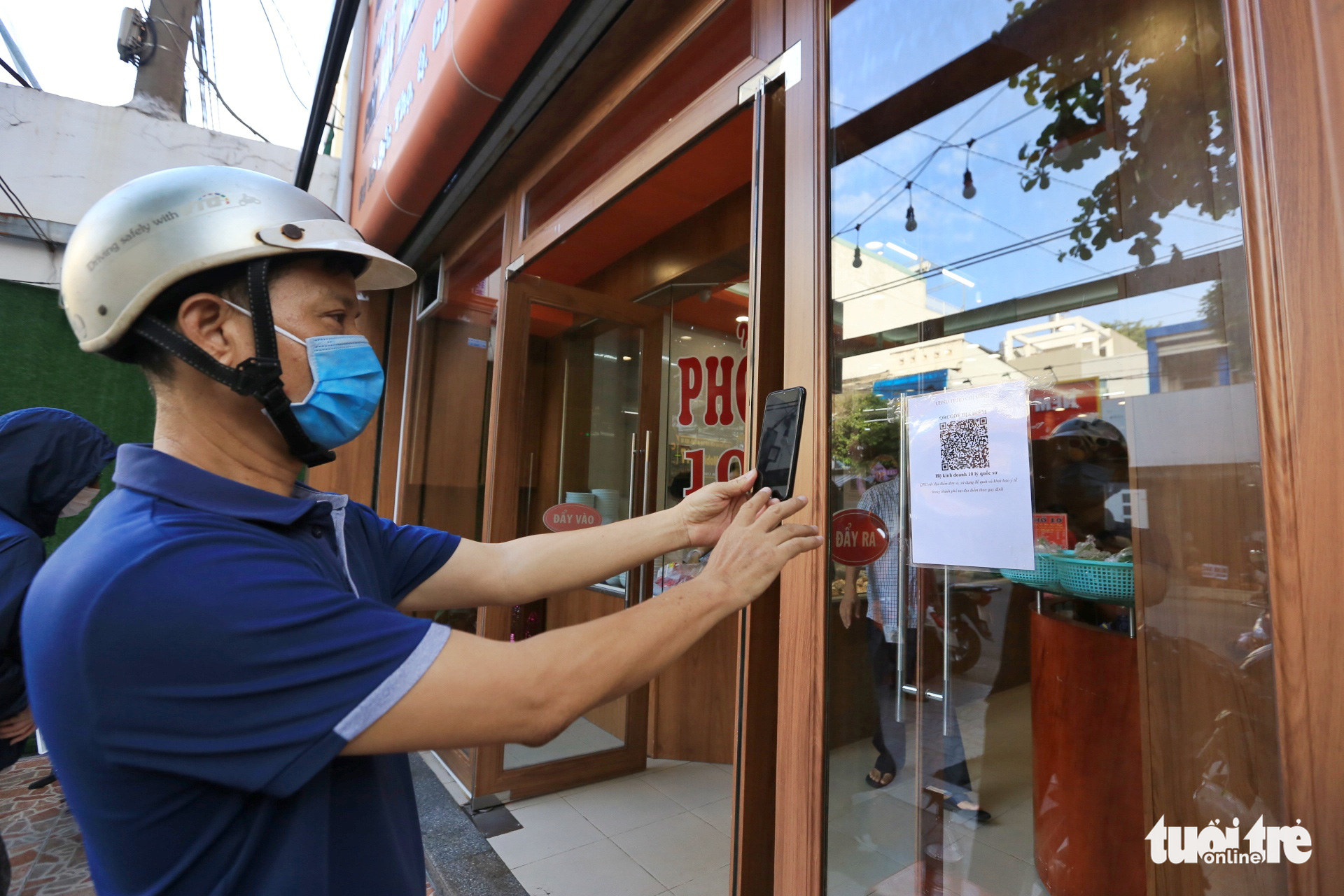 A customer scans QR code to file a health declaration upon arriving at an eatery in Go Vap District, Ho Chi Minh City, October 28, 2021. Photo: Nhat Thinh / Tuoi Tre