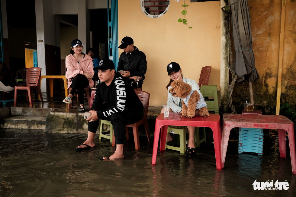 Customers bring their pet to a flooded café in Hoi An Ancient Town, Quang Nam Province, Vietnam, October 24, 2021. Photo: Tan Luc / Tuoi Tre