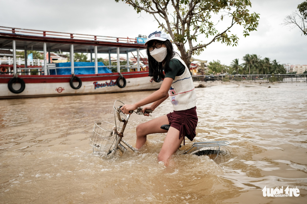 A woman rides her bicycle through the flood streets of Hoi An Ancient Town, Quang Nam Province, Vietnam, October 24, 2021. Photo: Tan Luc / Tuoi Tre